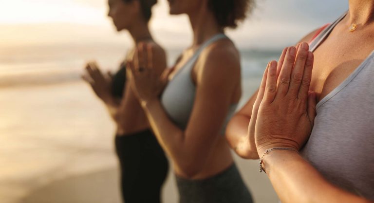 Foto de de mujeres practicando yoga en la playa en retiro de yoga en la costa brava