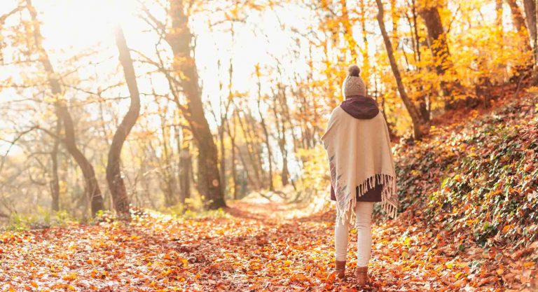 Foto de mujer paseando por un bosque en otoño en retiro de yoga en la costa brava