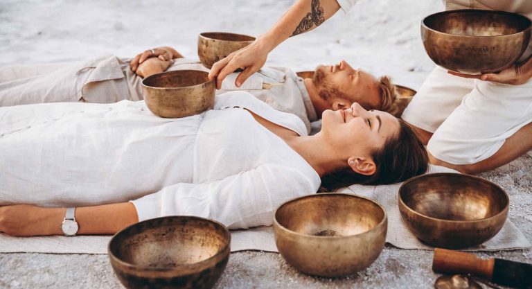Foto de Dos personas recibiendo sonoterapia con cuencos tibetanos