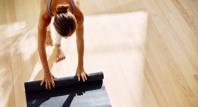 Foto de Chica desplegando su esterilla de yoga en retiro de yoga en Girona
